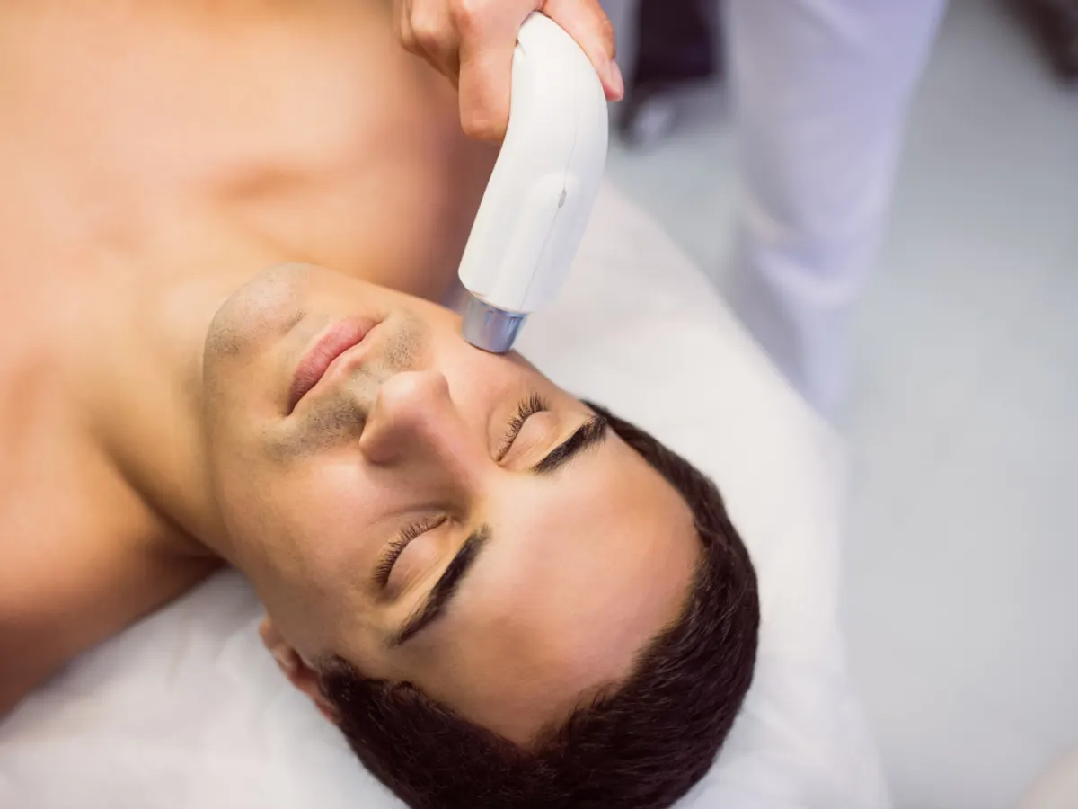 Homme allongé recevant un soin du visage