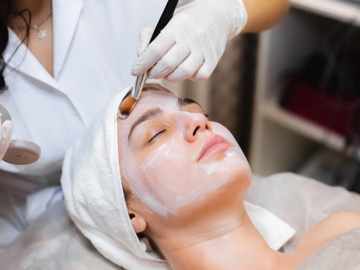 A mask being applied with a brush during a facial